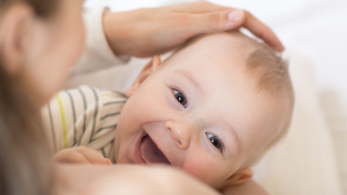 smiling baby breastfeeding
