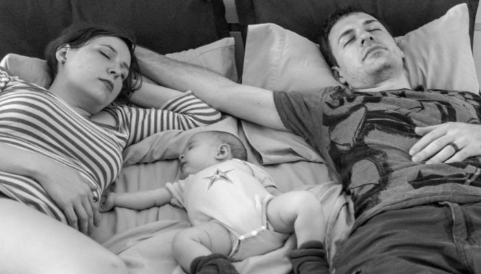 baby sleeping in bed with parents