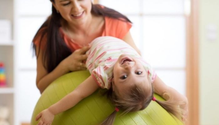 mom and toddler playing with exercise ball