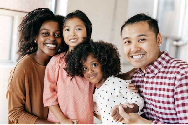a blended family smiles and poses for photo